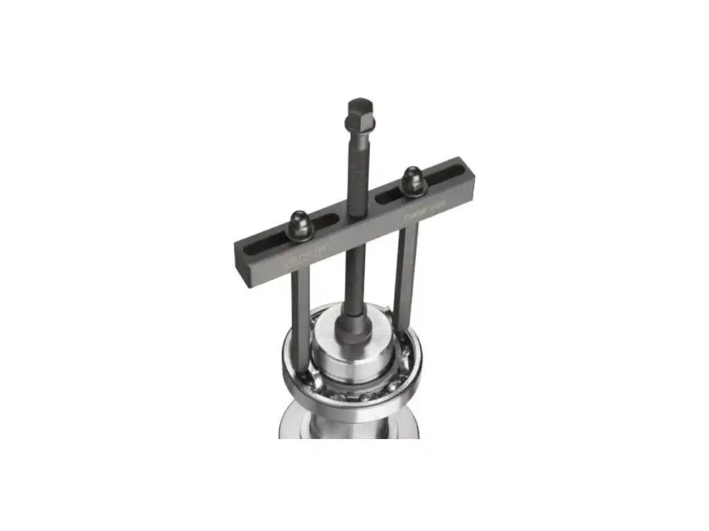 Heavy-duty bearing puller tool mounted on a metal bearing for industrial maintenance