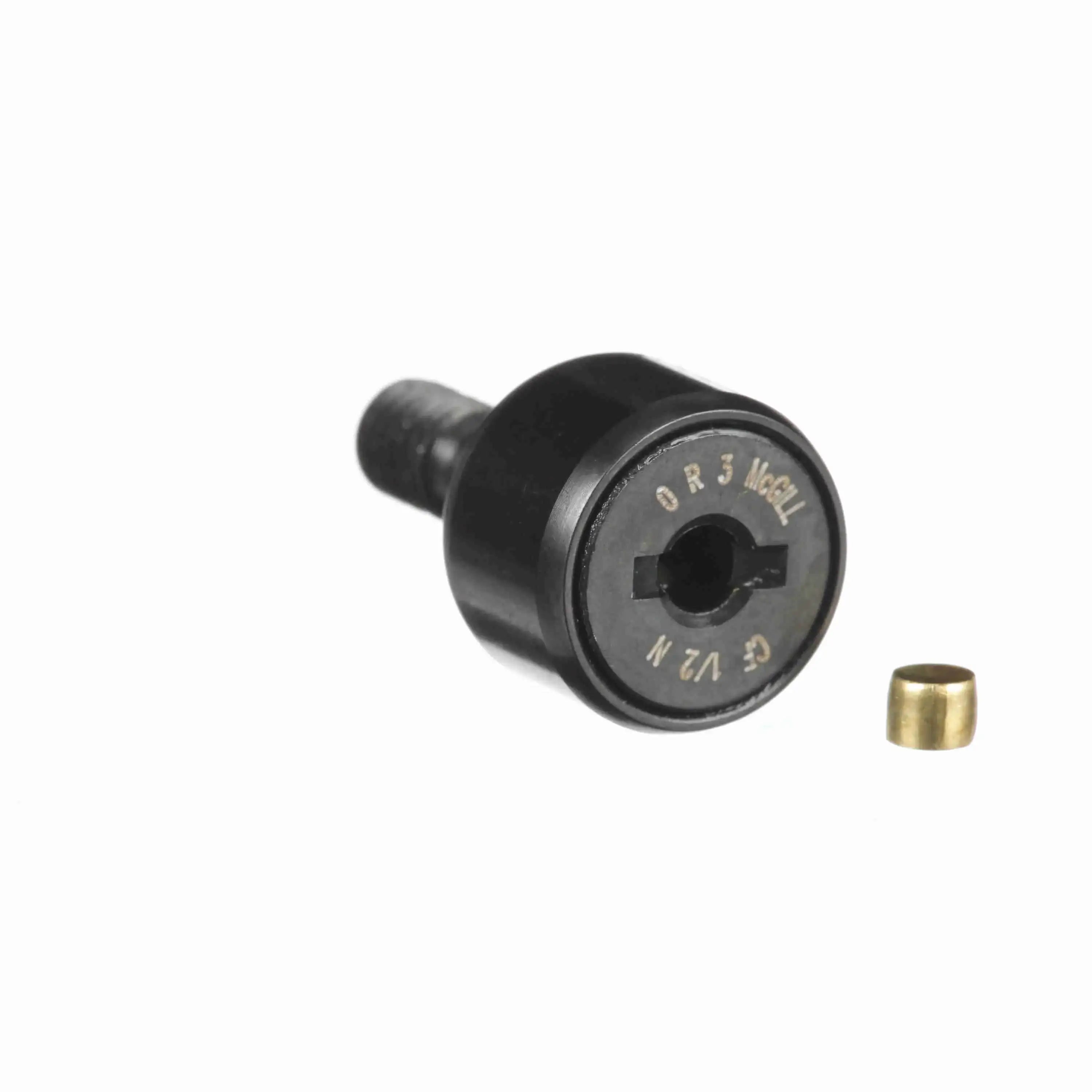 Black cam follower bearing with visible part markings and a small brass bushing on white background