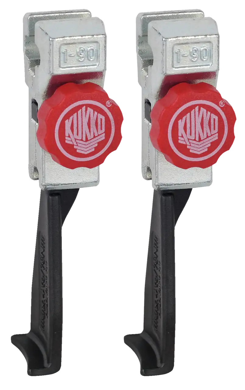 Pair of Kukko industrial puller tool clamps with red adjustment knobs and metal bodies