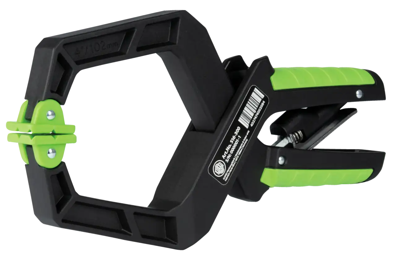 Heavy-duty black and green plastic spring clamp tool with textured grip for shop use